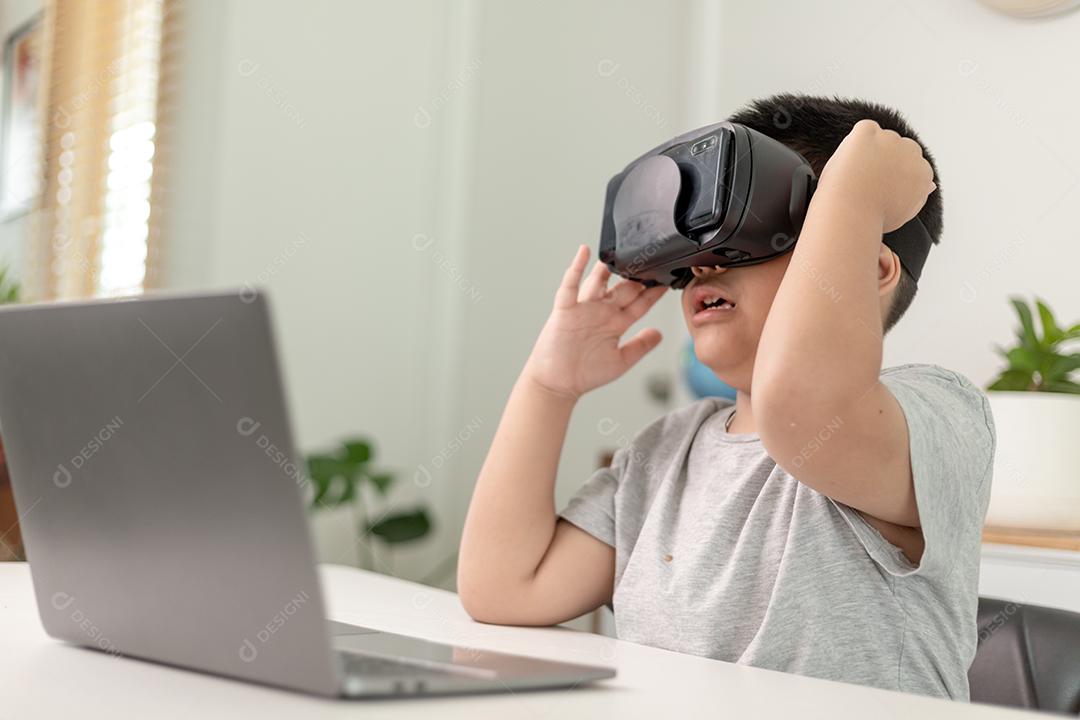 Menino asiático com óculos VR estudando ciências em casa, estudante curioso usa um fone de ouvido de realidade virtual para estudar ciência em casa estudo online estilo de vida futurista aprendizagem