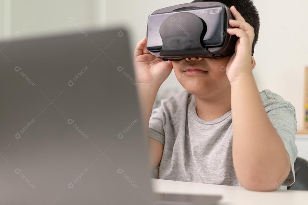 Menino asiático com óculos VR estudando ciências em casa, estudante curioso usa um fone de ouvido de realidade virtual para estudar ciência em casa estudo online estilo de vida futurista aprendizagem