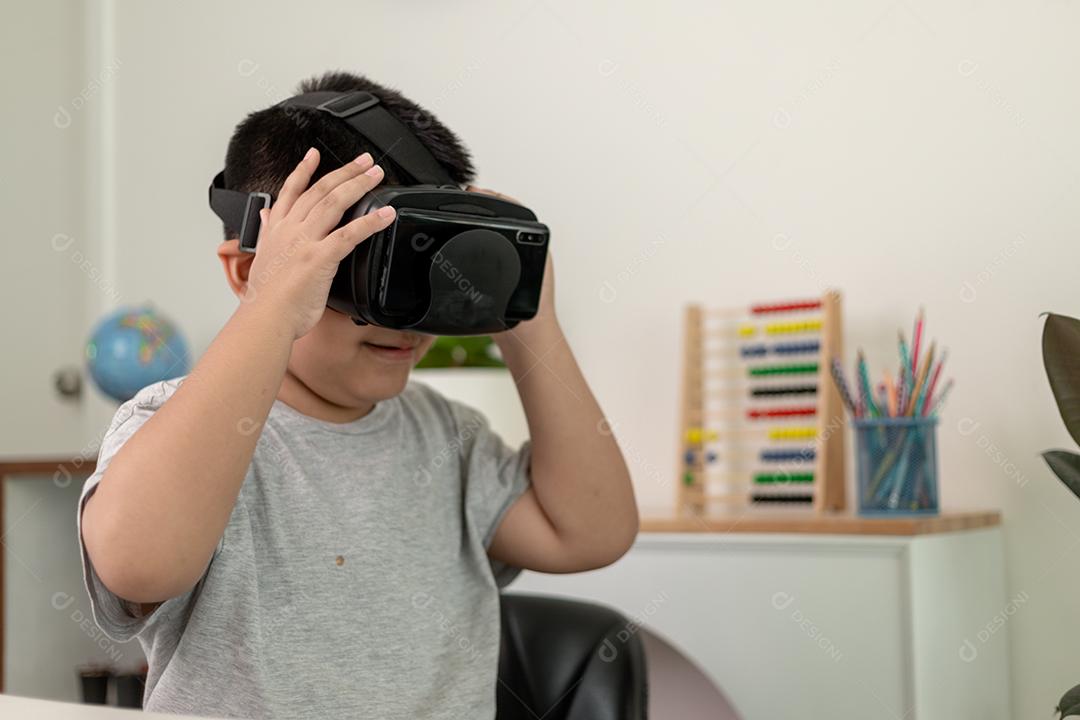 Menino asiático com óculos VR estudando ciências em casa, estudante curioso usa um fone de ouvido de realidade virtual para estudar ciência em casa estudo online estilo de vida futurista aprendizagem