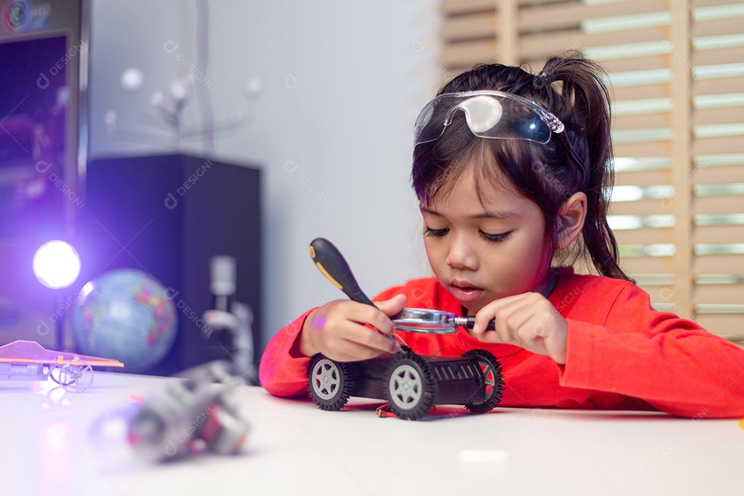 Os alunos da Ásia aprendem em casa na codificação de carros robóticos e cabos de placas eletrônicas em STEM, STEAM, código de computador de tecnologia de ciência de engenharia matemática em robótica para o conceito de crianças.