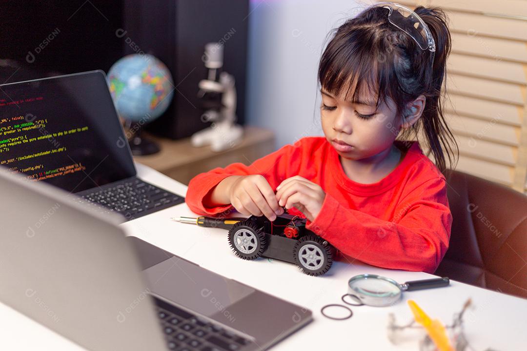 Os alunos da Ásia aprendem em casa na codificação de carros robóticos e cabos de placas eletrônicas em STEM, STEAM, código de computador de tecnologia de ciência de engenharia matemática em robótica para o conceito de crianças.