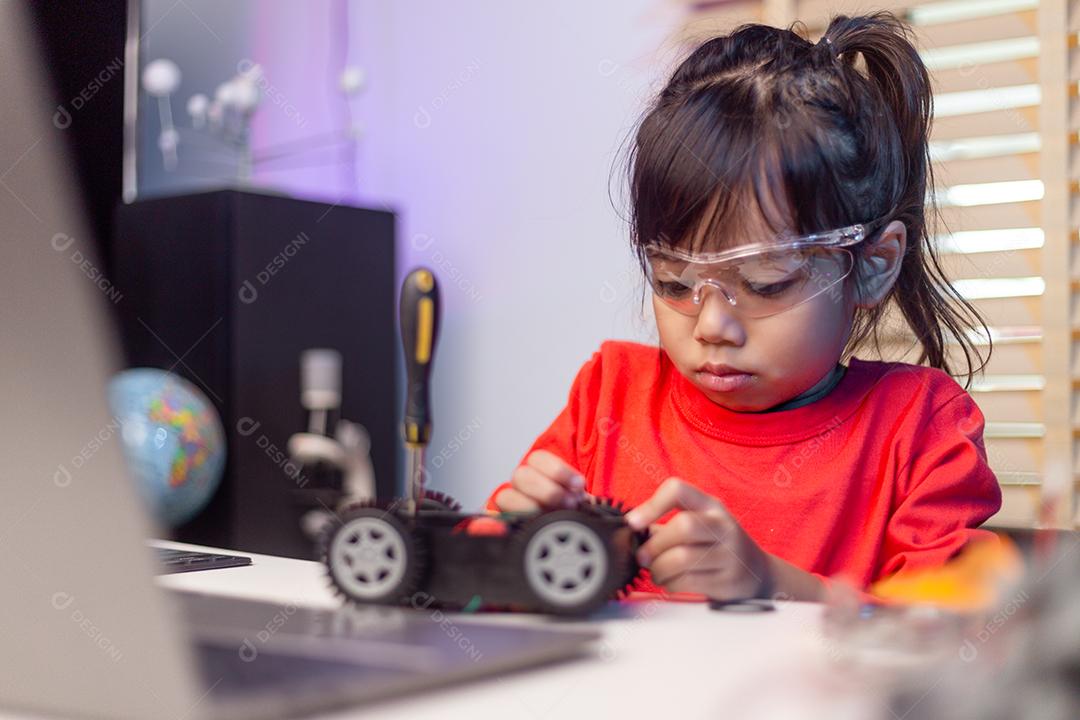 Os alunos da Ásia aprendem em casa na codificação de carros robóticos e cabos de placas eletrônicas em STEM, STEAM, código de computador de tecnologia de ciência de engenharia matemática em robótica para o conceito de crianças.