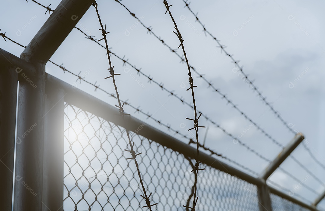 Cerca de segurança da prisão. Cerca de fronteira. Cerca de segurança de arame farpado. Cerca de prisão de arame farpado. Muro de segurança