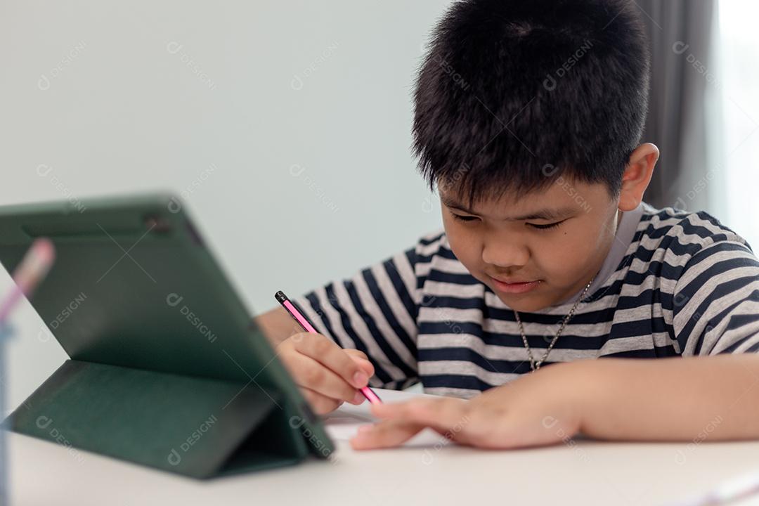 Child self-isolation using tablet for his homework, Child using digital tablet searching information on internet during covid 19 lockdown, Home education, Social distance, E-learning online education