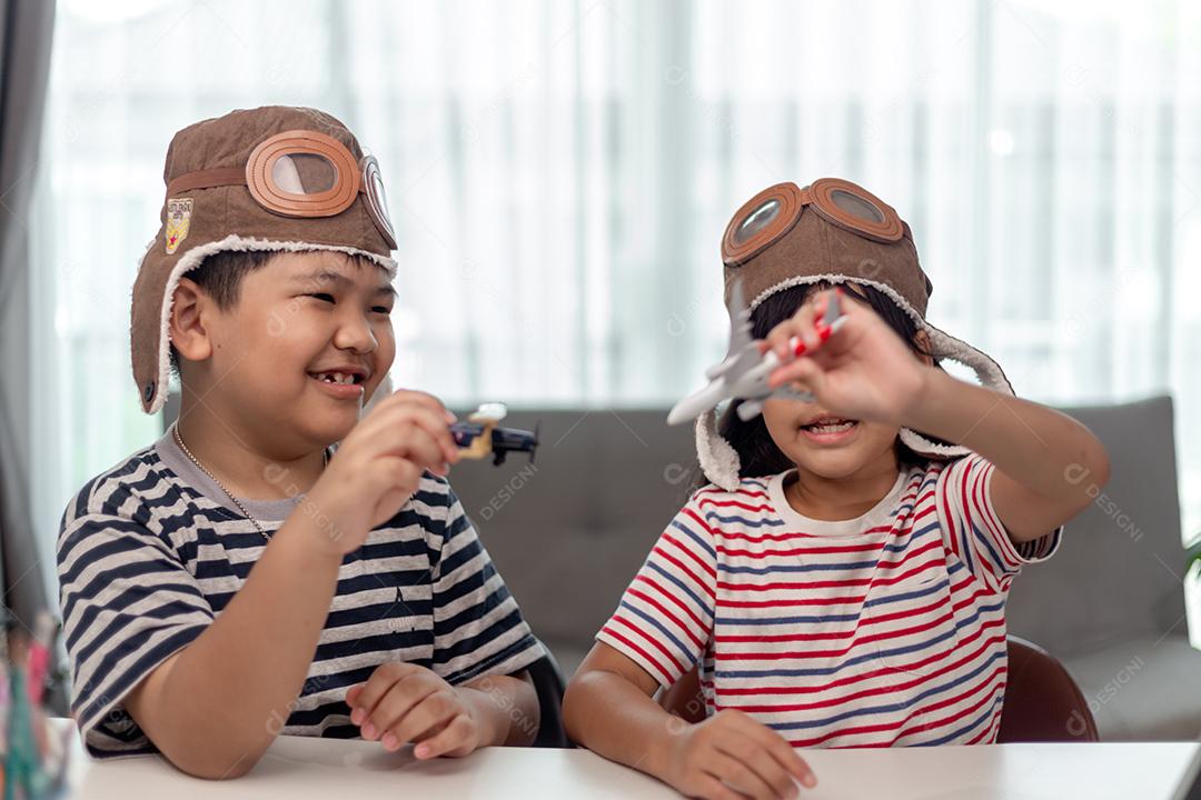 Duas crianças com aviões nas mãos