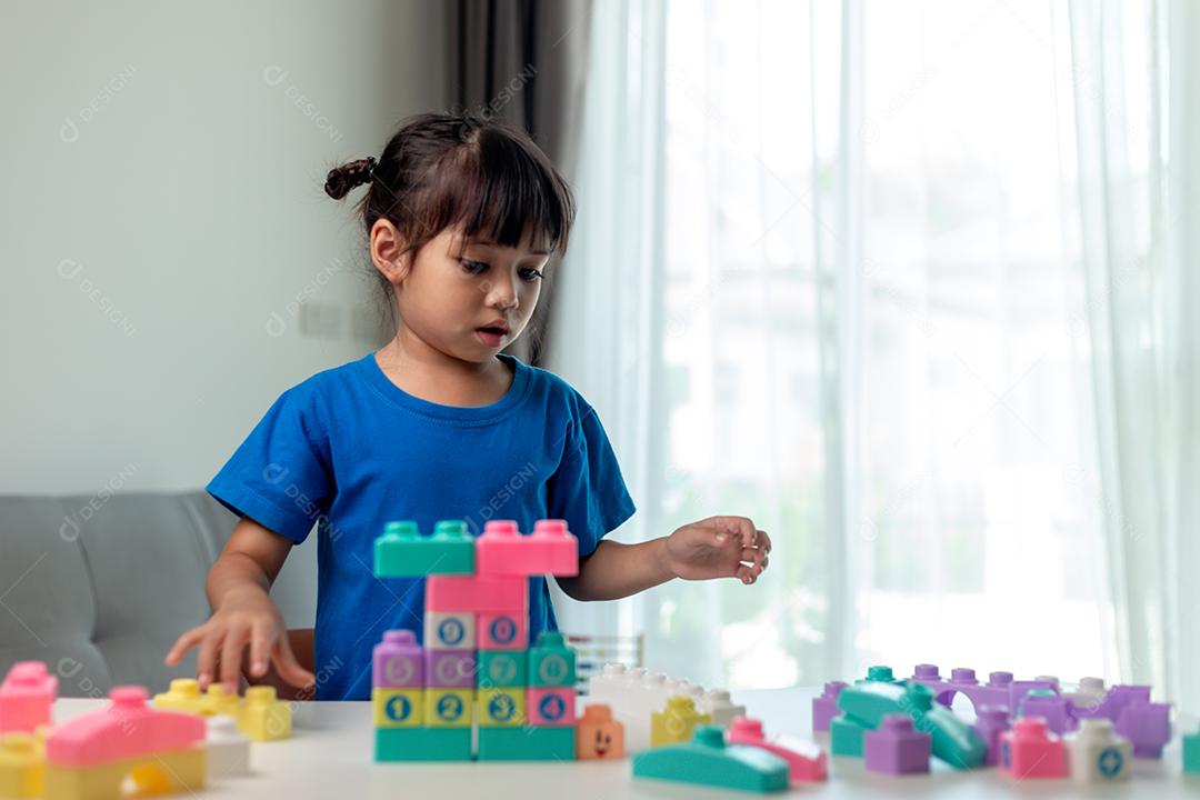 Menina criança jogando blocos coloridos