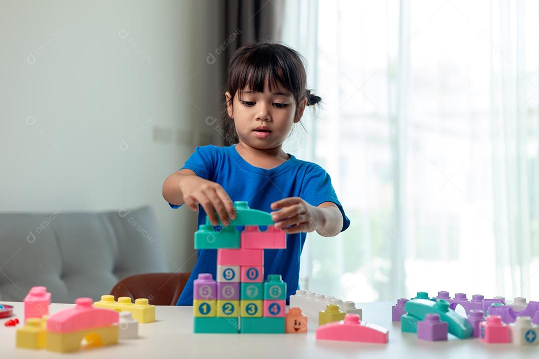 Menina criança jogando blocos coloridos