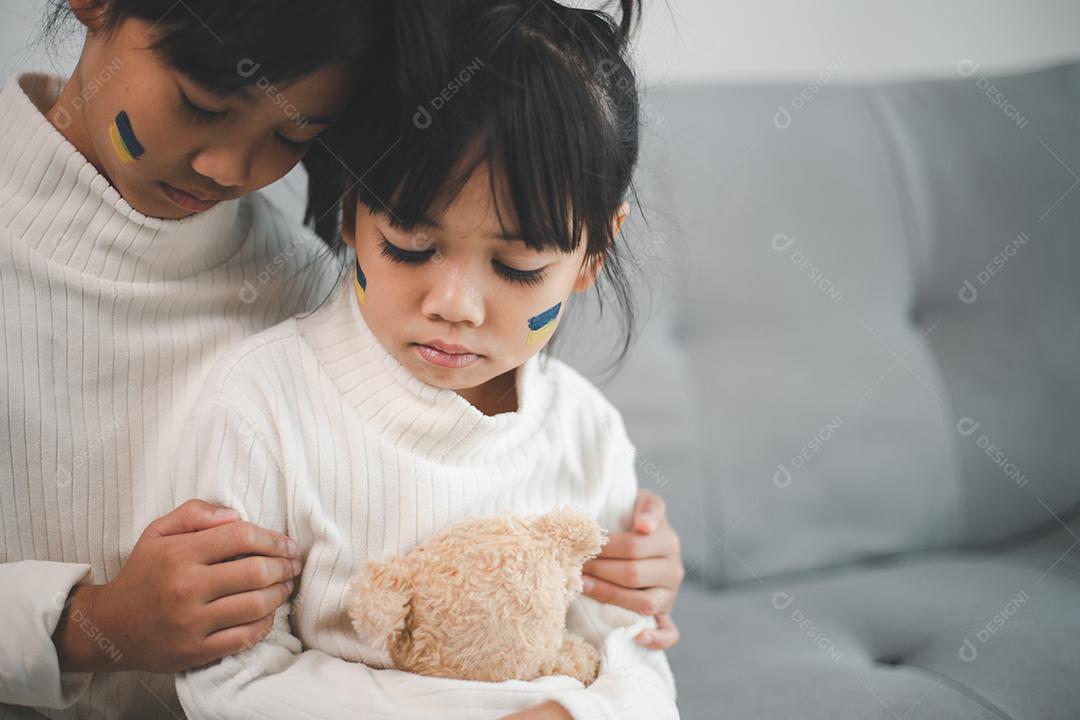 Uma criança com a bandeira da Ucrânia está chorando. Tristeza desejando esperança. As lágrimas das crianças da guerra. Evacuação de civis. Liberdade para a Ucrânia