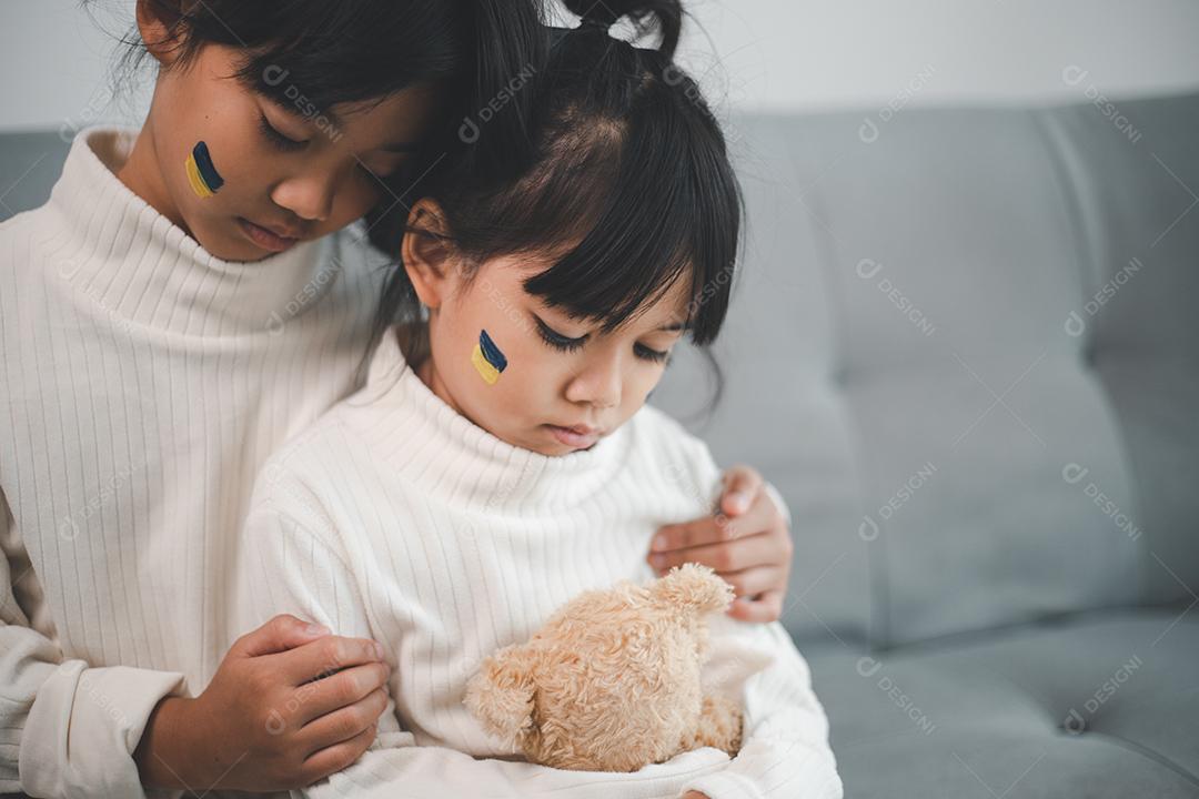 Uma criança com a bandeira da Ucrânia está chorando. Tristeza desejando esperança. As lágrimas das crianças da guerra. Evacuação de civis. Liberdade para a Ucrânia