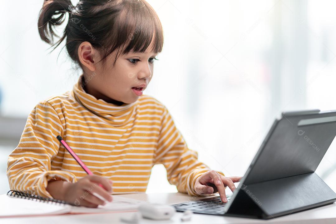 Auto-isolamento infantil usando tablet para sua lição de casa, Criança usando tablet digital pesquisando informações na internet durante o bloqueio covid 19, Educação em casa, Distância social, E-learning educação on-line