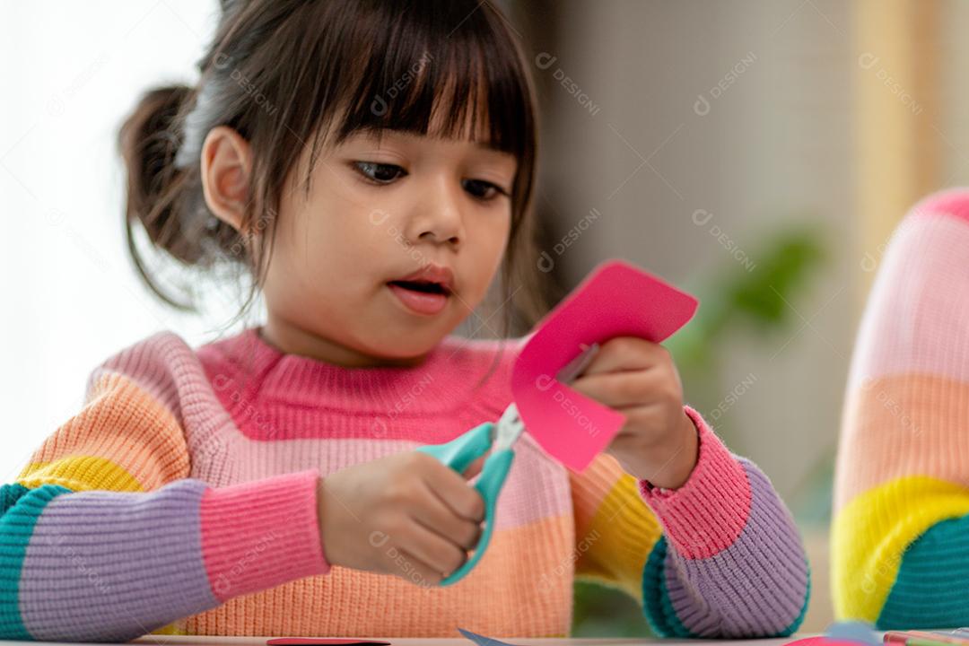 Retrato de uma menina asiática cortando um papel em atividades na aula de bricolage na School.Scissors corta papel.