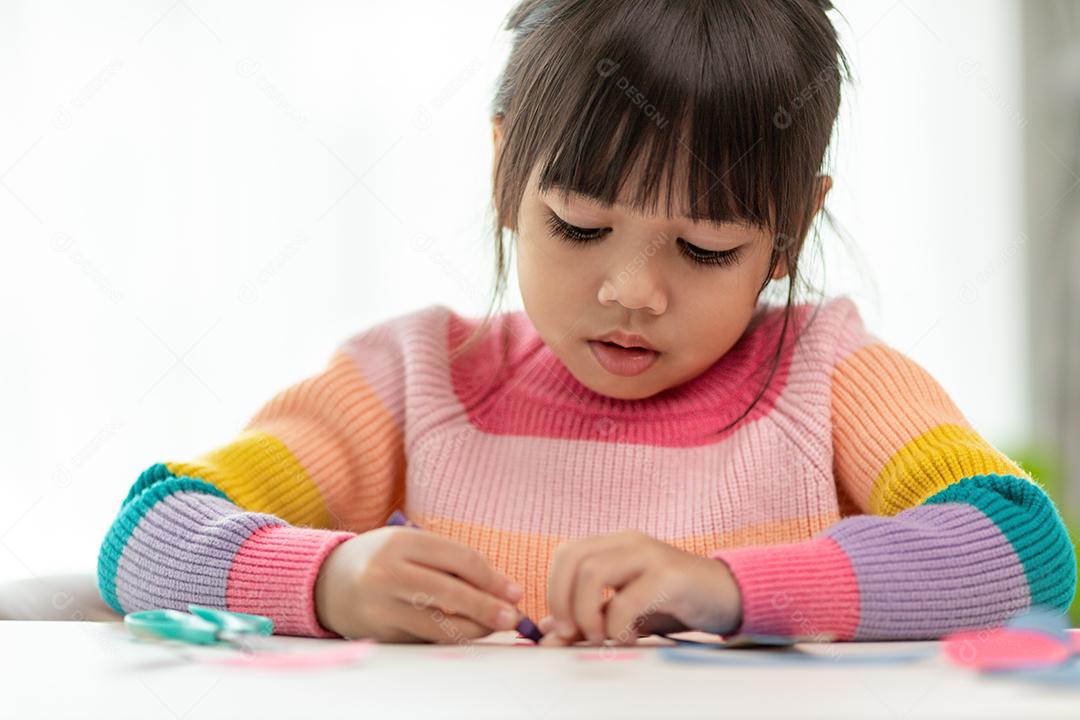 Menina bonita com núcleo de tecido pintado. A arte faz as crianças aprenderem e criarem.