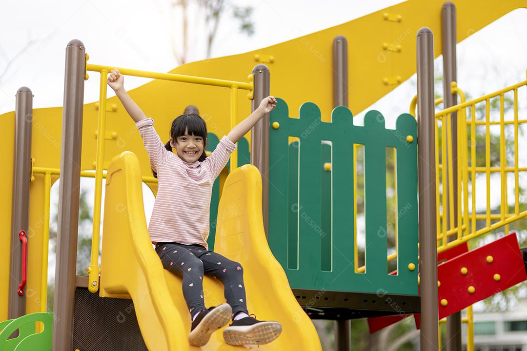 Criança brincando no playground ao ar livre. As crianças brincam na escola ou no jardim de infância. Garoto ativo no escorregador colorido e balanço. Atividade de verão saudável para crianças. Garotinho escalando ao ar livre.