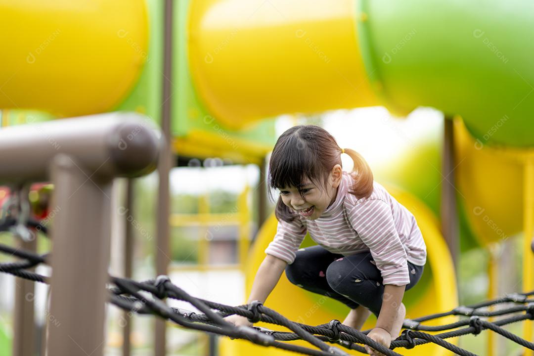 Criança brincando no playground ao ar livre. As crianças brincam na escola ou no jardim de infância. Garoto ativo no escorregador colorido e balanço. Atividade de verão saudável para crianças. Garotinho escalando ao ar livre.