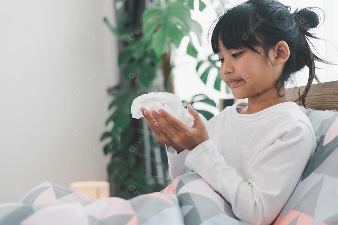 menina fica com frio e assoa o nariz em casa.