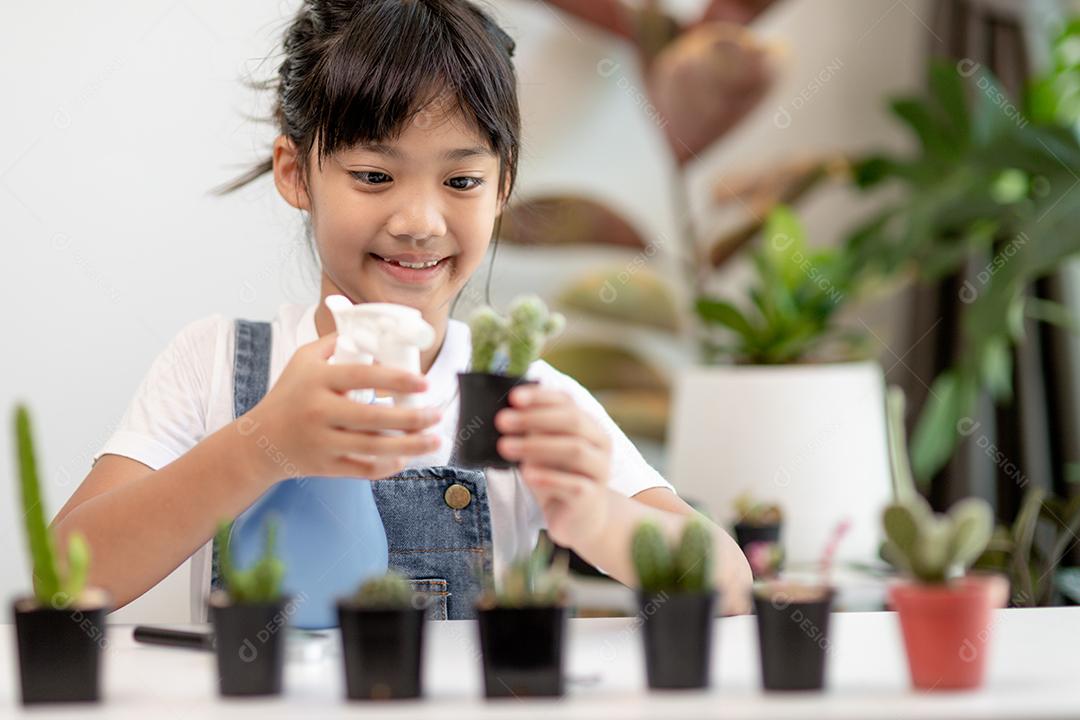 Menina asiática está plantando plantas em casa, conceito de atividade de aprendizado de crescimento de plantas para uma criança pré-escolar e educação infantil para a árvore na natureza