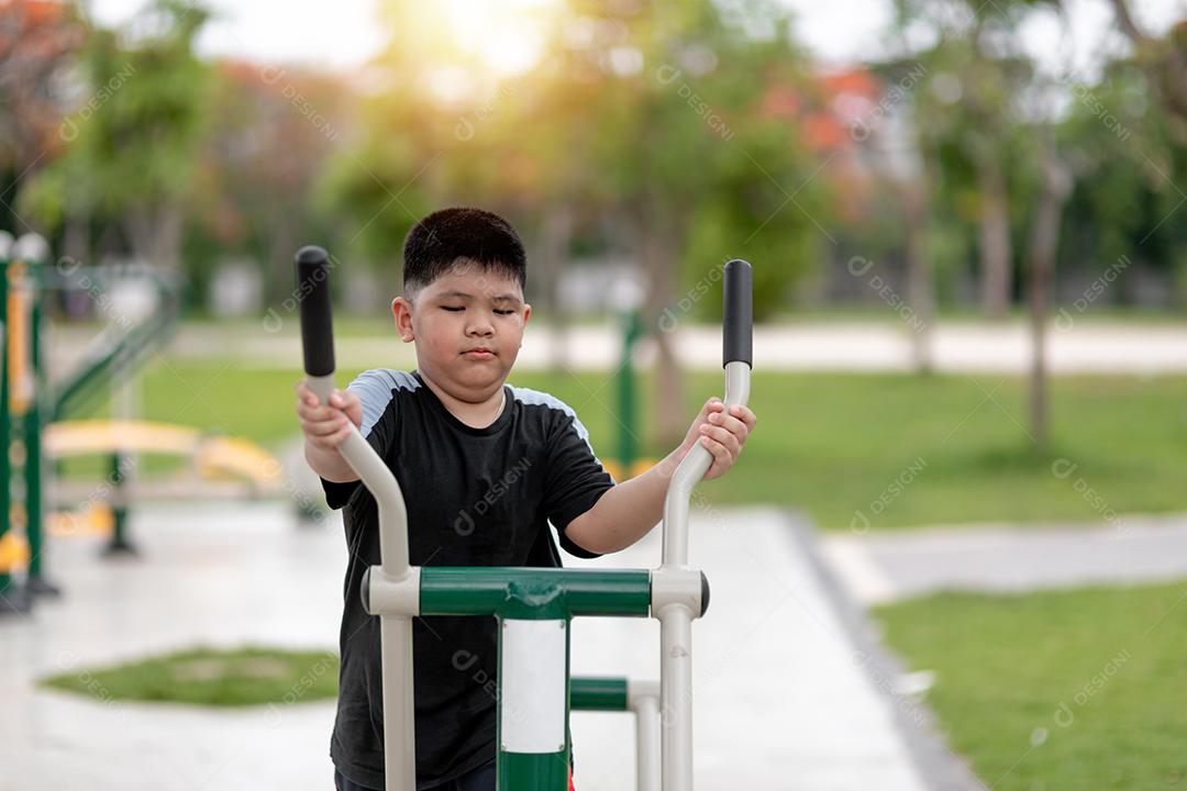 gordo treina em equipamentos de ginástica no parque