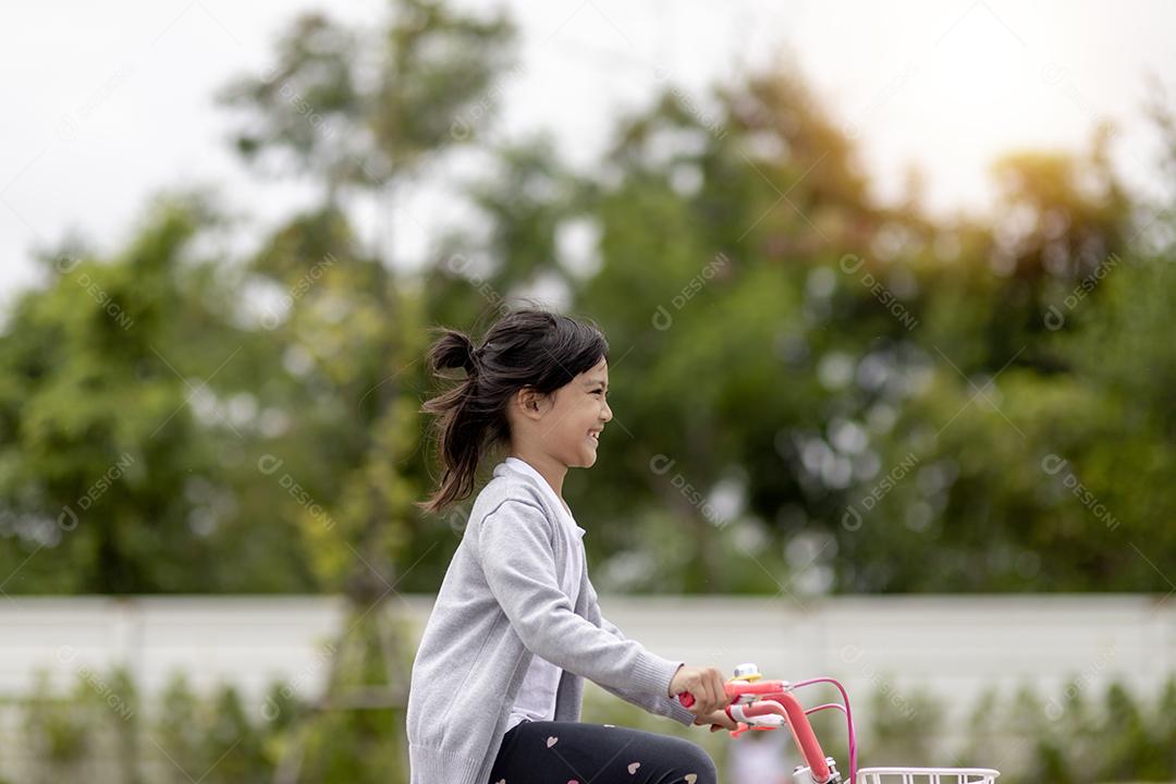 menina criança alegre feliz andando de bicicleta no parque na natureza