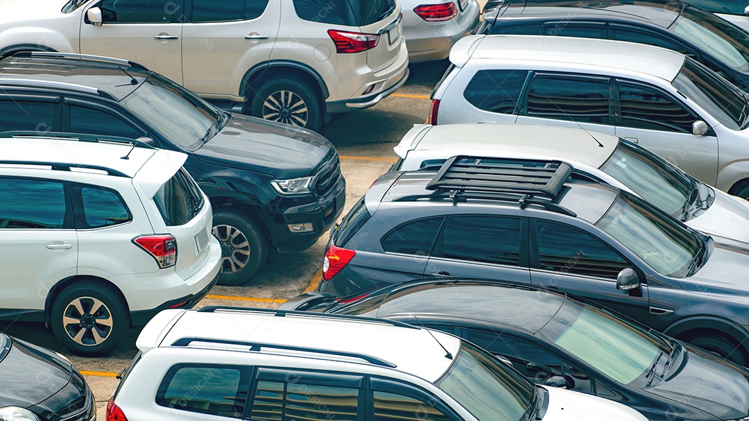 Carro branco e preto estacionado no estacionamento de concreto do shopping em férias. Vista aérea da área de estacionamento ao ar livre