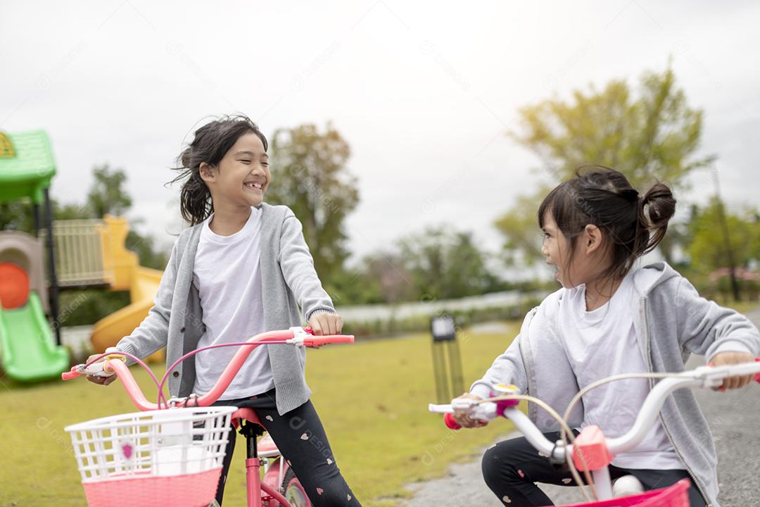 menina criança alegre feliz andando de bicicleta no parque na natureza