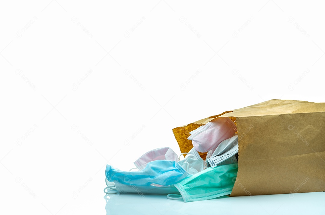 Máscara facial cirúrgica usada em saco de papel pardo isolado no fundo branco. Lixo hospitalar. Resíduos infecciosos da crise de coronavírus