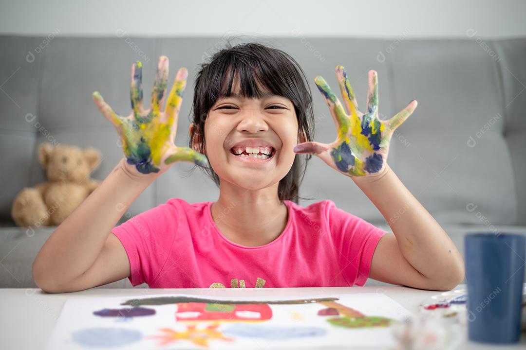 conceito de educação, escola, arte e painitng - garotinha estudante mostrando as mãos pintadas