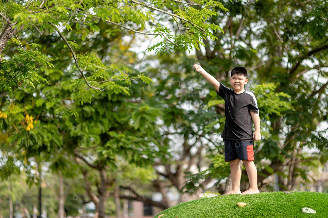 Menina asiática brincando no playground no parque ao ar livre Momento feliz e boa emoção