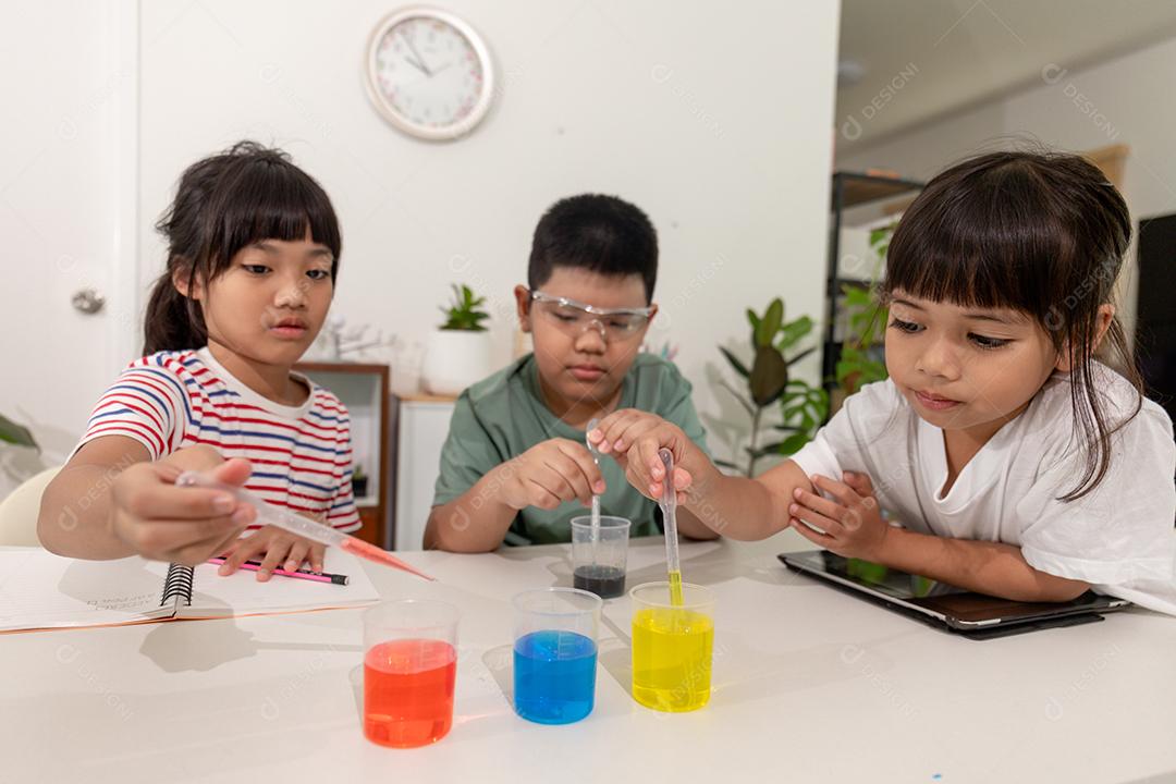 Crianças asiáticas fazem experimentos químicos em casa