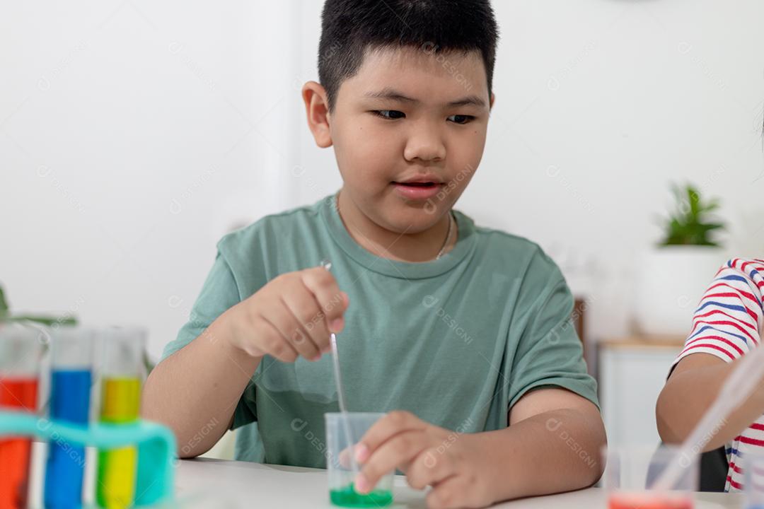 Crianças asiáticas fazem experimentos químicos em casa
