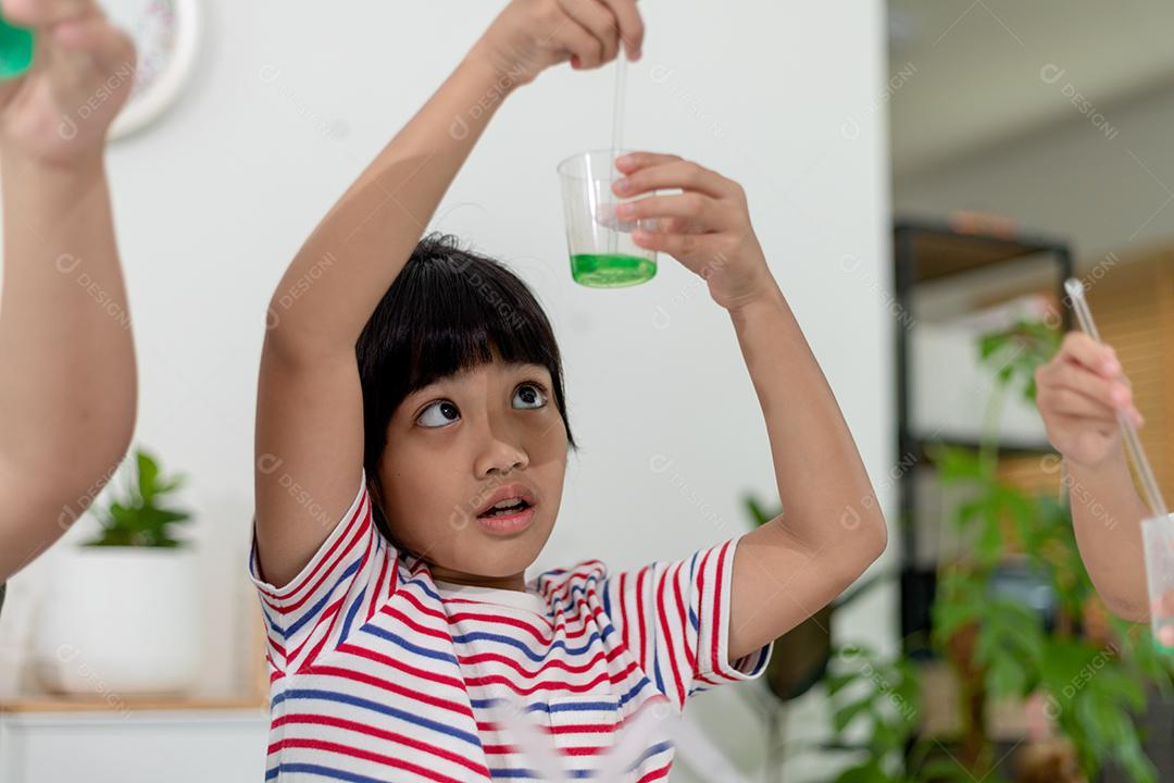 Asian children enthusiastically watch chemistry experiments.