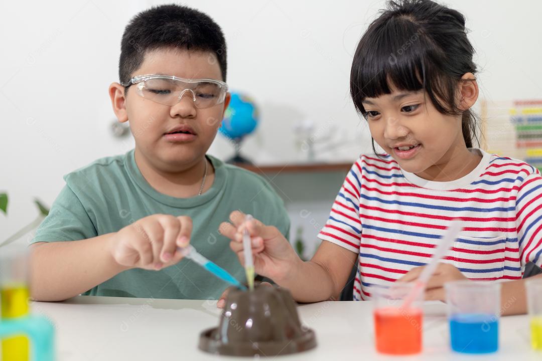 Crianças repetindo e observando um projeto de laboratório de ciências em casa - o vulcão de bicarbonato de sódio e vinagre