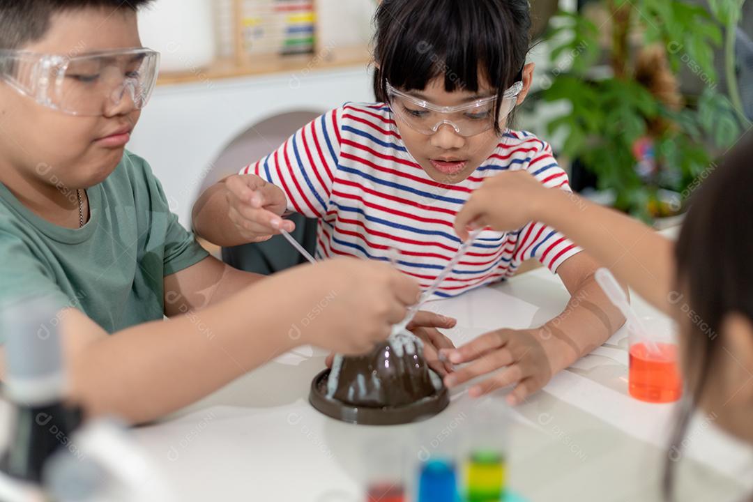 Crianças repetindo e observando um projeto de laboratório de ciências em casa - o vulcão de bicarbonato de sódio e vinagre