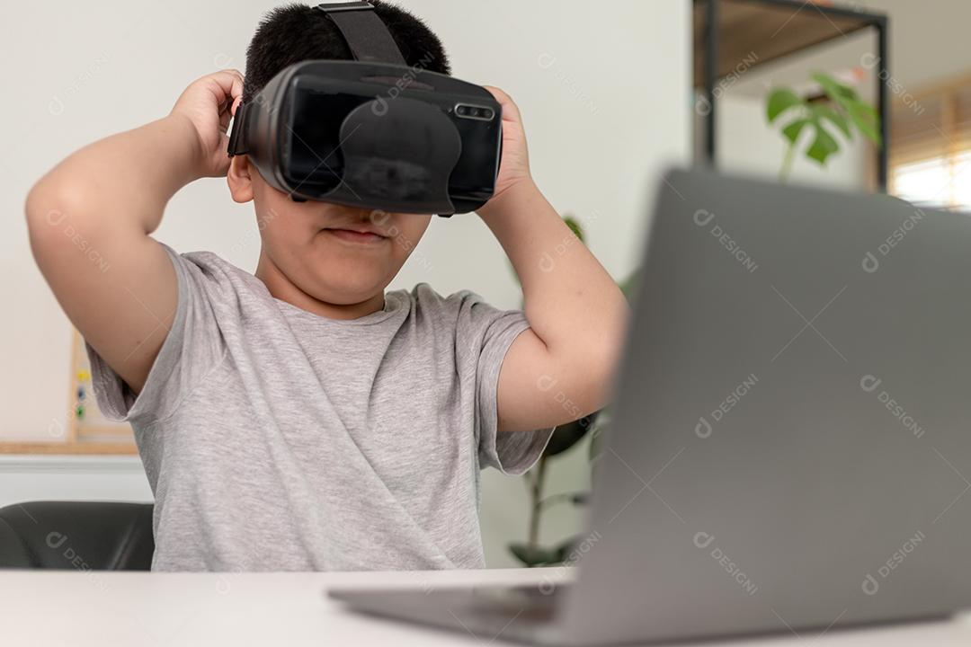 Menino asiático com óculos VR estudando ciências em casa, estudante curioso usa um fone de ouvido de realidade virtual para estudar ciência em casa estudo online estilo de vida futurista aprendizagem