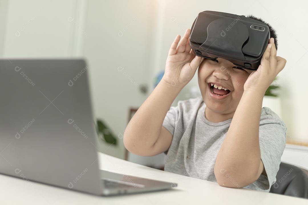 Menino asiático com óculos VR estudando ciências em casa, estudante curioso usa um fone de ouvido de realidade virtual para estudar ciência em casa estudo online estilo de vida futurista aprendizagem