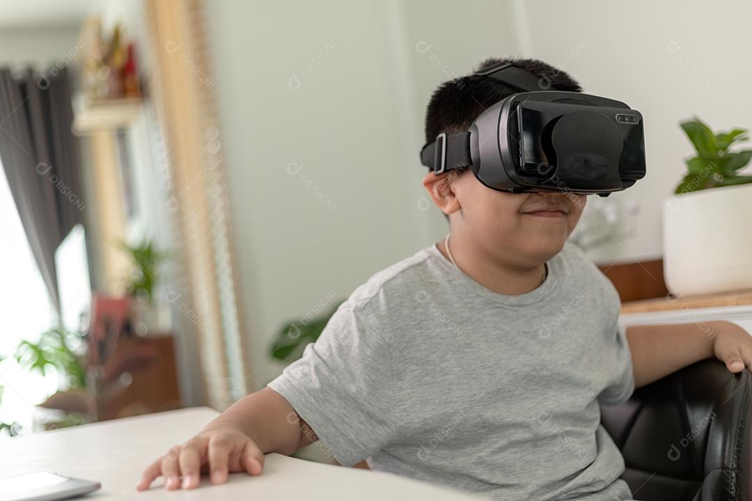 Menino asiático com óculos VR estudando ciências em casa, estudante curioso usa um fone de ouvido de realidade virtual para estudar ciência em casa estudo online estilo de vida futurista aprendizagem