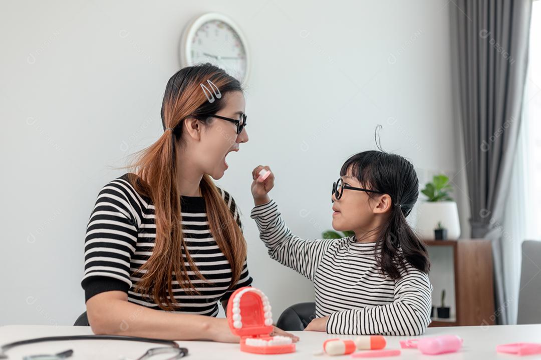 Futuro médico verificando a dentadura da mãe em casa.