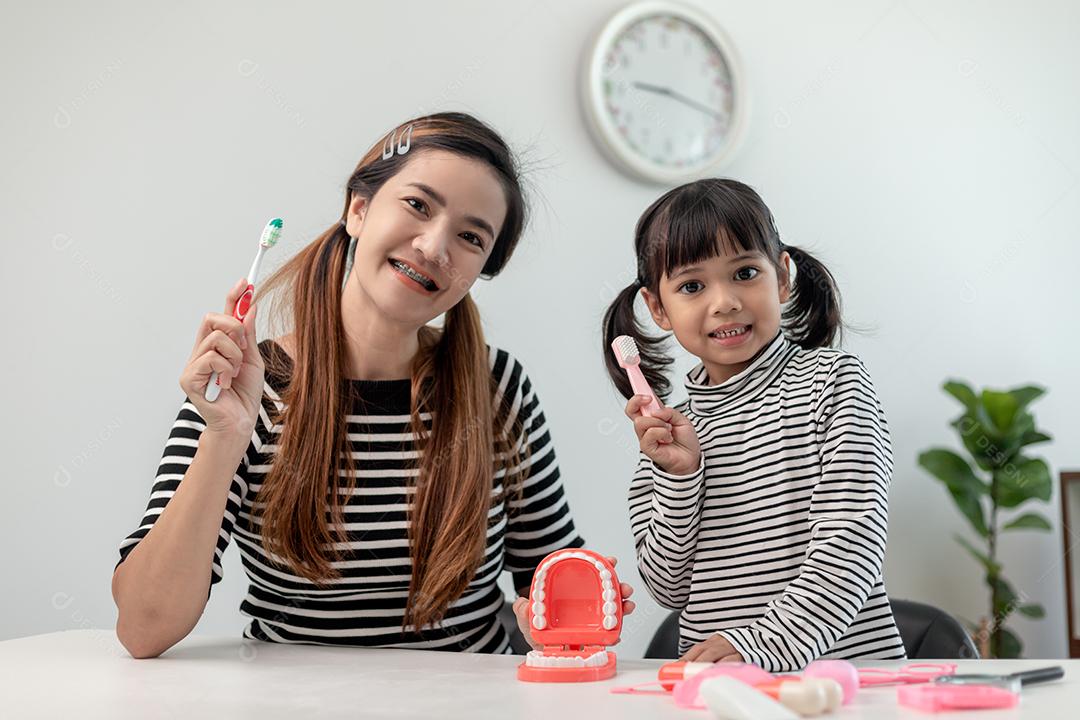 Família feliz e saúde. menina mãe e filha escovando seus dentes