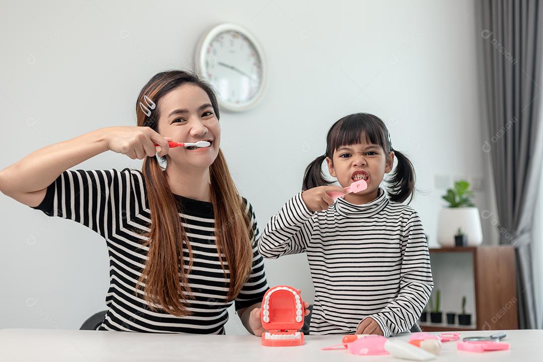 Família feliz e saúde. menina mãe e filha escovando seus dentes