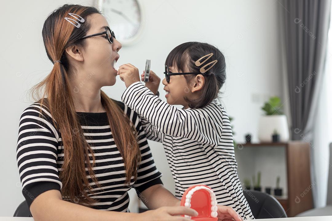 Futuro médico verificando a dentadura da mãe em casa.