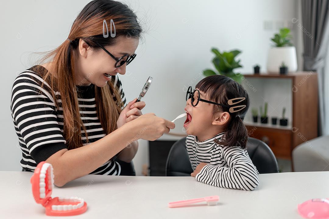 mother checks daughters baby teeth. The teeth grow in two rows. child