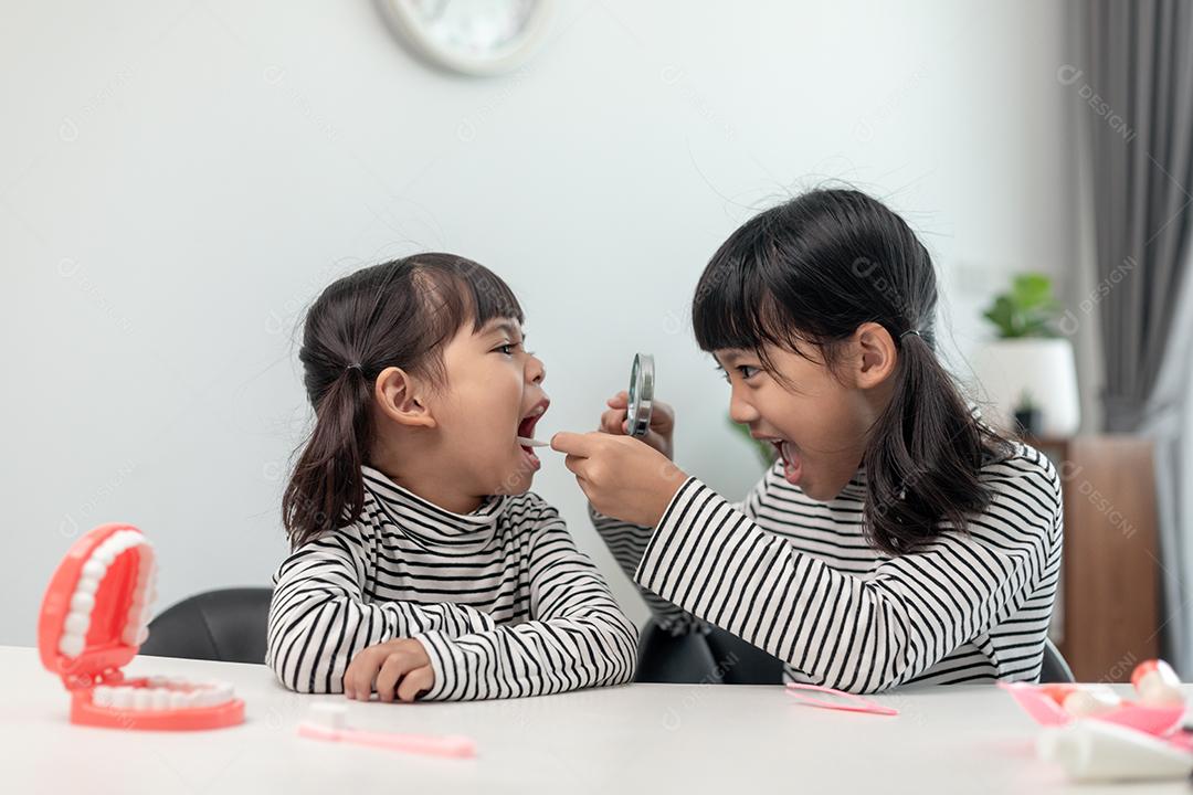 Linda criança asiática brincando com conjunto de brinquedos de dentista médico, show infantil