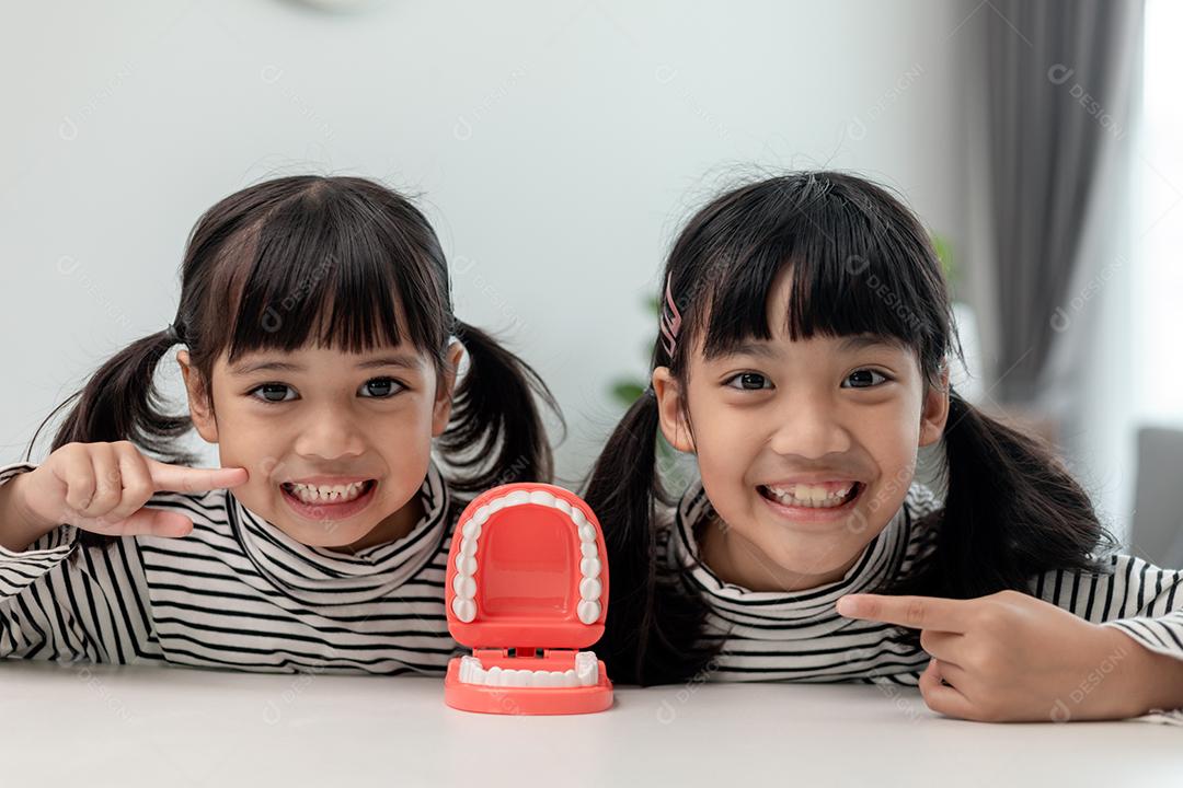 Linda criança asiática brincando com conjunto de brinquedos de dentista médico, show infantil