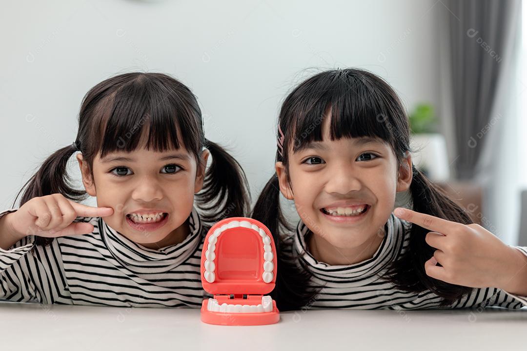 Linda criança asiática brincando com conjunto de brinquedos de dentista médico, show infantil
