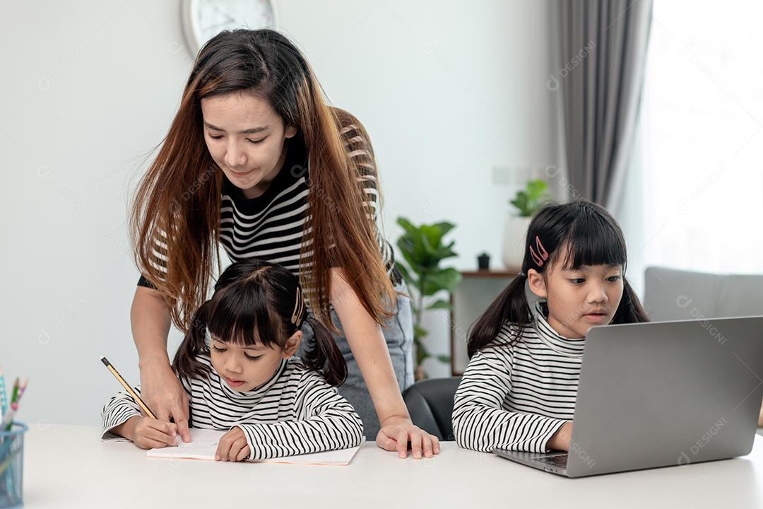 Garotinhas asiáticas aprendendo aula online em casa com mãe