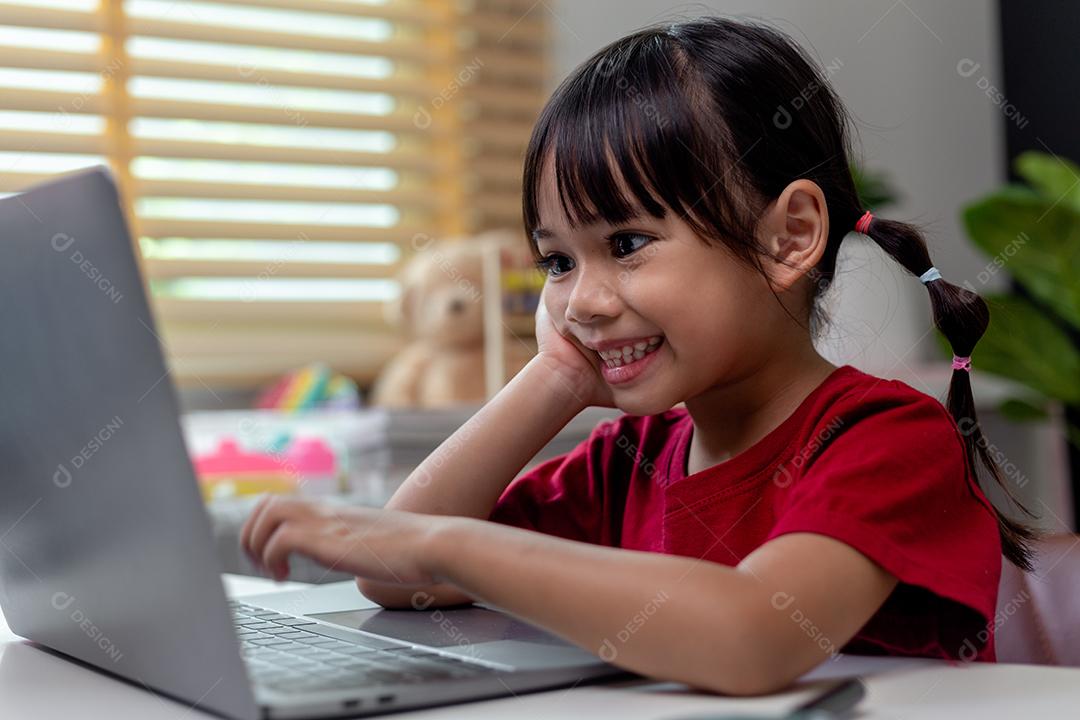 Menina asiática usando computador portátil para estudo on-line homeschooling