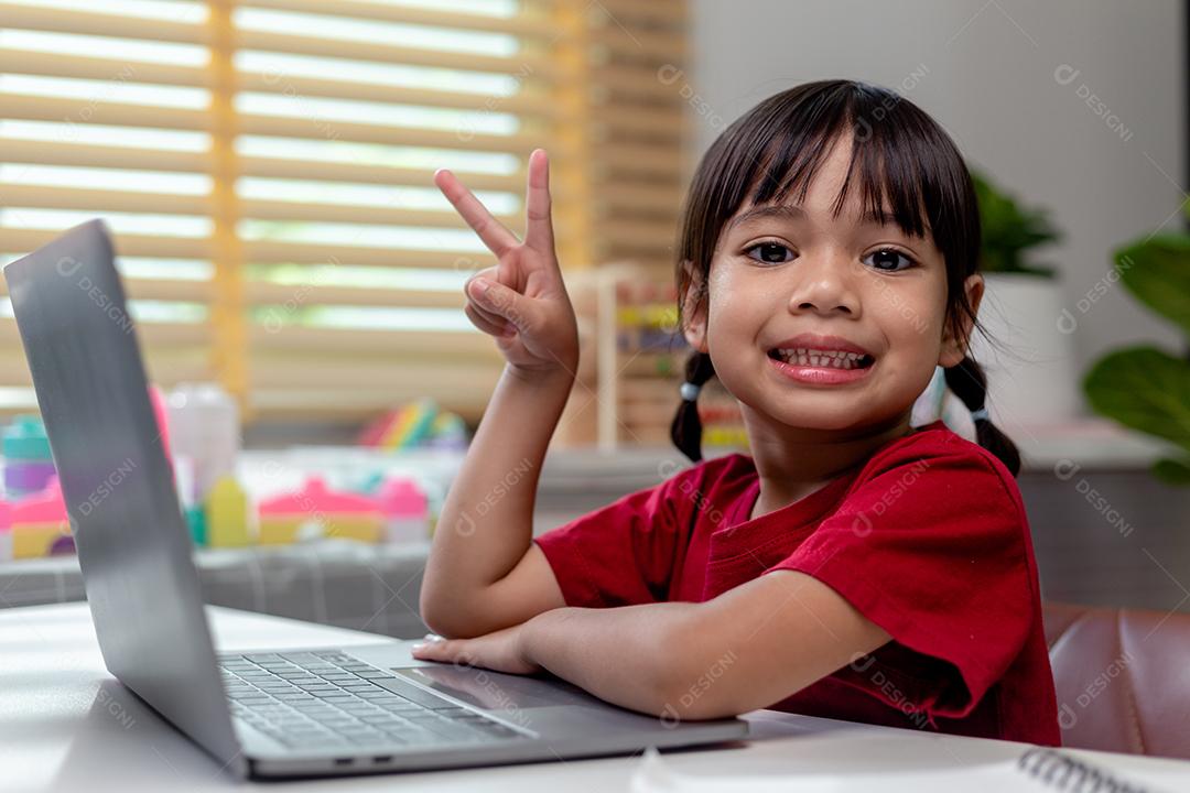 Menina asiática usando computador portátil para estudo on-line homeschooling