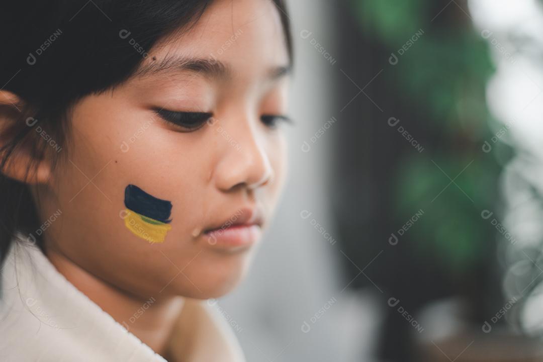 Uma criança com a bandeira da Ucrânia está chorando. Tristeza saudade esperança