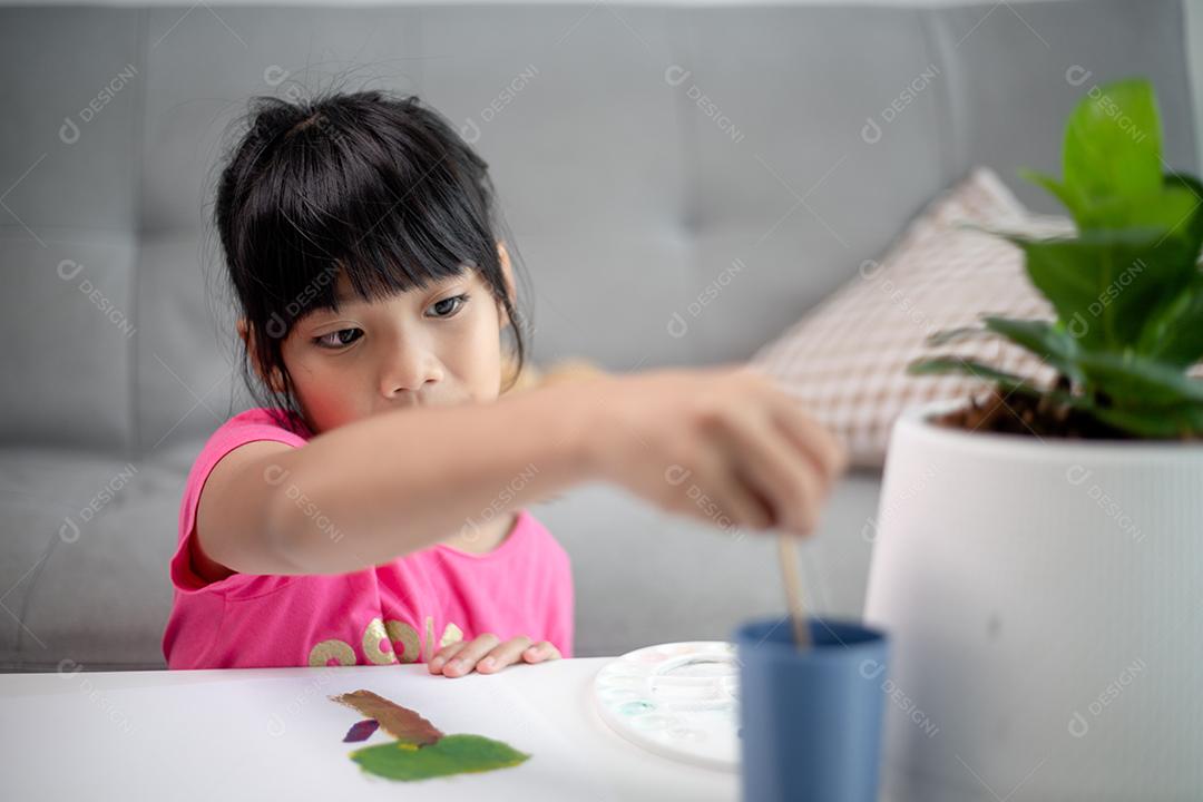 Menina pintando quadro na mesa em casa