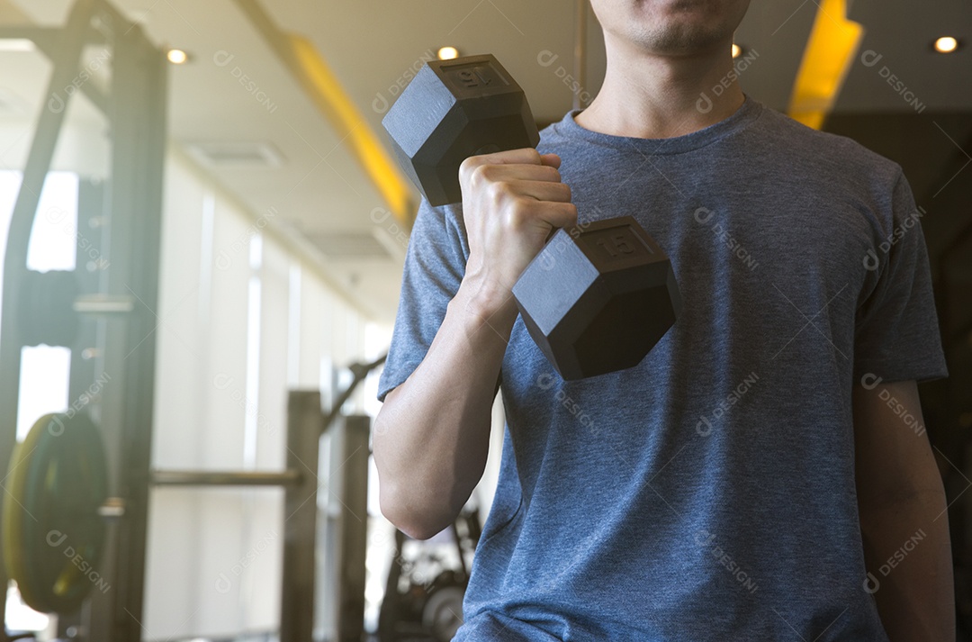 Jovem iniciante exercitando com halteres flexionando os músculo