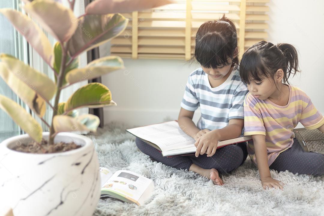 Irmãos concentrados lendo um livro